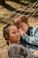Two children sharing secrets while - Credits: pexels