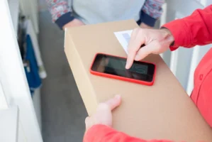 A person signs a package - Credits: pexels