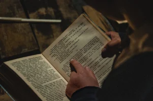 Hands reading an open book, - Credits: pexels