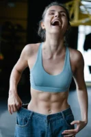 Fit young woman happily shows - Credits: pexels