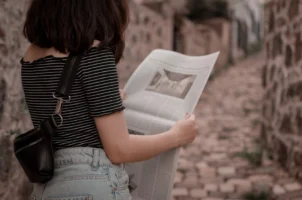 A woman stands outdoors on - Credits: pexels