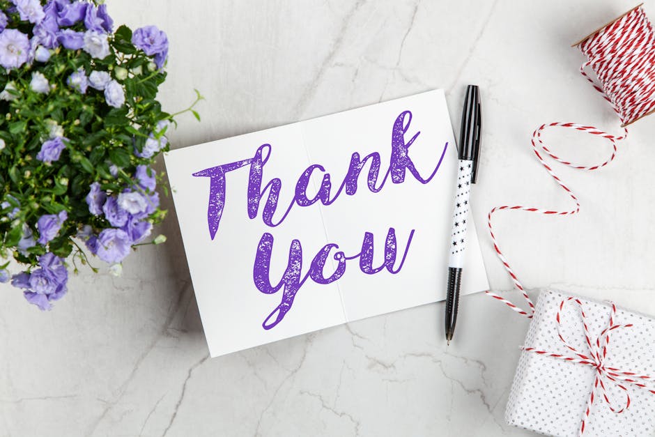 A stylish thank you card paired with purple flowers, a gift box, and pen on a marble surface. - Credits: pexels